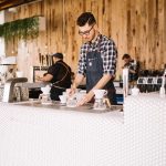 カフェのカウンターで作業するスタッフ・洗い場や裏方作業のイメージ