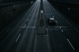 薄暗い早朝の道路を走る車。静かな道を進みながら、初めての隙間バイトへ向かう緊張と落ち着きを表した写真