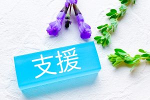 青いガラスブロックに「支援」と書かれた写真。障がい者支援の取り組みを象徴するイメージ。