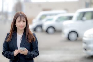自動車ディーラーの敷地内で業務に向かう女性スタッフの様子