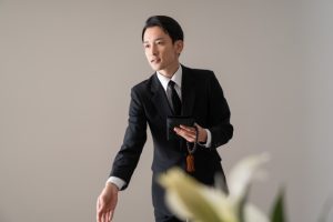 黒い礼服姿で案内する葬儀スタッフのイメージ