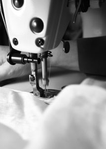 白い布を縫い合わせる工業用ミシンのアップ