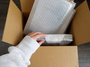 段ボールに商品を入れて発送準備をしている梱包作業の様子