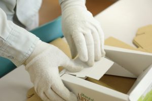 手袋をした作業員が段ボール箱を組み立てている様子
