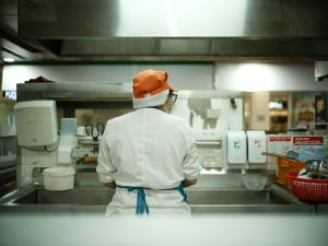 ホテルの厨房で洗い場作業をしているスタッフの後ろ姿