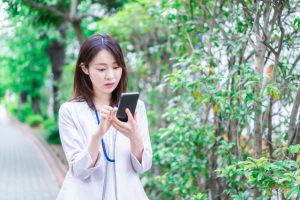 スマホでツアー情報や変更点を確認する添乗員のイメージ写真