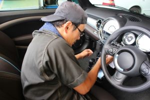 中古車の運転席まわりを清掃する車内清掃作業