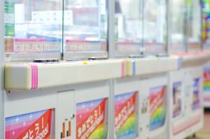 クレーンゲームが並ぶゲームセンターで景品対応をする単発バイトのイメージ