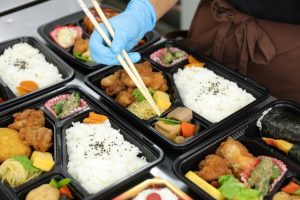 スーパーの惣菜売り場に、パック詰めされた惣菜や弁当が並んでいる様子